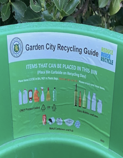 A recycling guide sticker on the inside of the green recycling bin